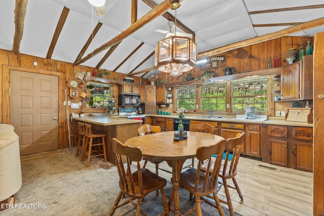 2255 Citico Rd, Vonore, TN 37885 - dining room featuring wooden walls, light wood-style floors, beam ceiling, a chandelier, and high vaulted ceiling