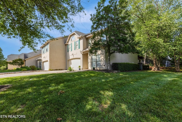 614 Chapel Point Ln, Knoxville, TN 37934 - view of front of house featuring an attached garage, driveway, stucco siding, and a front lawn