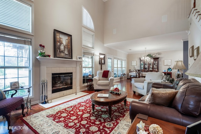 614 Chapel Point Ln, Knoxville, TN 37934 - living room with a towering ceiling, a tiled fireplace, a chandelier, healthy amount of natural light, and wood finished floors
