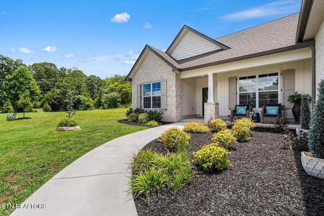 140 Walelu Trl, Vonore, TN 37885 - doorway to property with a porch, a lawn, a shingled roof, board and batten siding, and brick siding