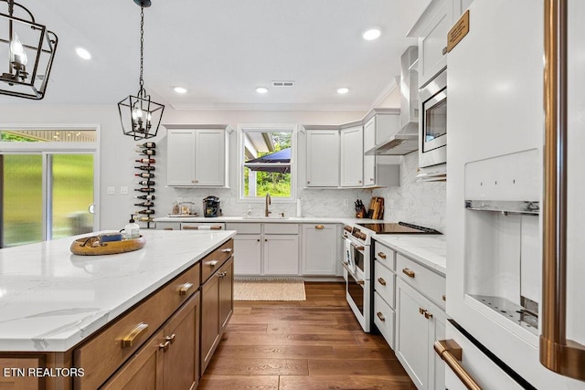 140 Walelu Trl, Vonore, TN 37885 - kitchen featuring appliances with stainless steel finishes, dark wood-style floors, decorative light fixtures, wall chimney range hood, and backsplash
