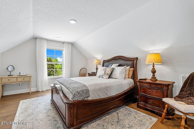 140 Walelu Trl, Vonore, TN 37885 - bedroom with a textured ceiling, vaulted ceiling, and wood finished floors