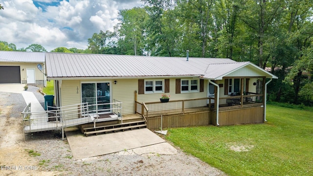 1010 Smallwood Rd, Jamestown, TN 38556 - back of house featuring a yard, a metal roof, a deck, a garage, and driveway