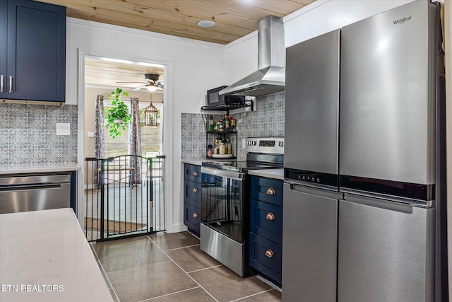 1010 Smallwood Rd, Jamestown, TN 38556 - kitchen featuring appliances with stainless steel finishes, wall chimney range hood, blue cabinets, dark tile patterned floors, and tasteful backsplash