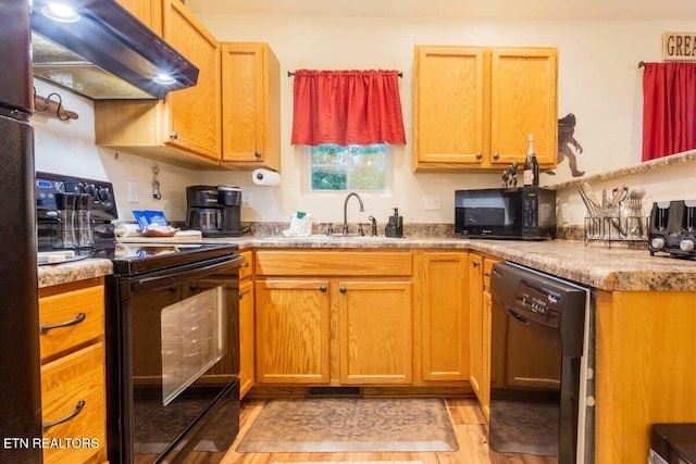 541 Johnson Ln Unit 2, Gatlinburg, TN 37738 - kitchen with black appliances, exhaust hood, light wood-style flooring, and light countertops
