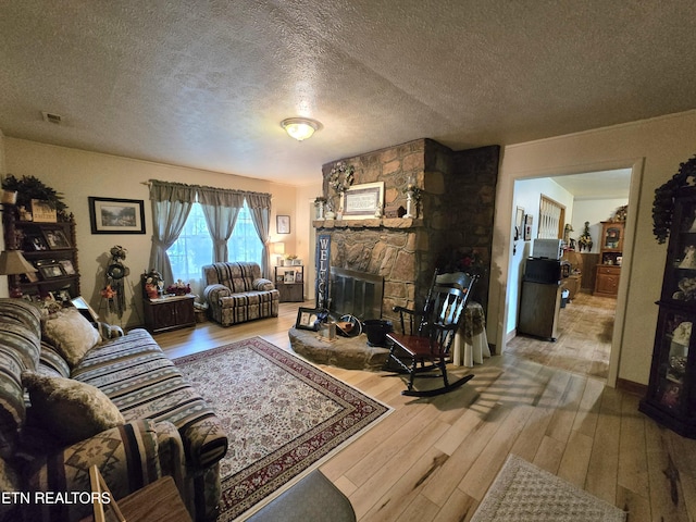 340 Machine Branch Rd, Ewing, VA 24248 - living room with hardwood / wood-style floors, a stone fireplace, and a textured ceiling