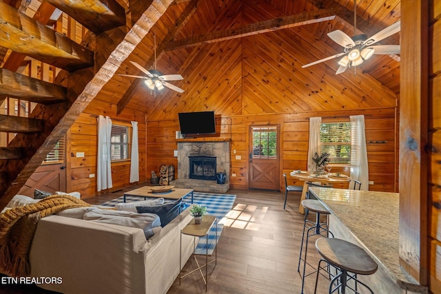 4372 Boogertown Rd Unit 2, Sevierville, TN 37876 - living room with ceiling fan, a wooden ceiling with exposed beams, a fireplace, wood walls, and dark wood-type flooring
