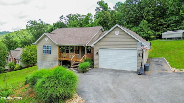 667 Pine Hollow Rd, Jacksboro, TN 37757 - single story home with covered porch, asphalt driveway, a front yard, an attached garage, and roof with shingles