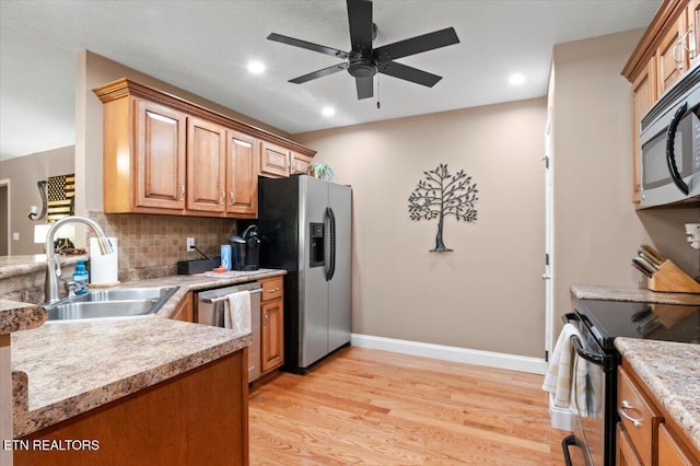 667 Pine Hollow Rd, Jacksboro, TN 37757 - kitchen featuring stainless steel appliances, a ceiling fan, light wood-style flooring, decorative backsplash, and light countertops
