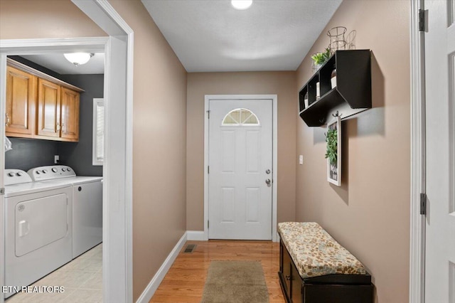 667 Pine Hollow Rd, Jacksboro, TN 37757 - laundry area featuring washing machine and dryer, cabinet space, and light wood-style flooring