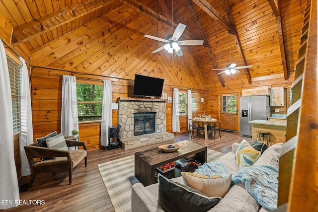 4372 Boogertown Rd Unit 4, Sevierville, TN 37876 - living area featuring healthy amount of natural light, wooden walls, a stone fireplace, wood finished floors, and a ceiling fan