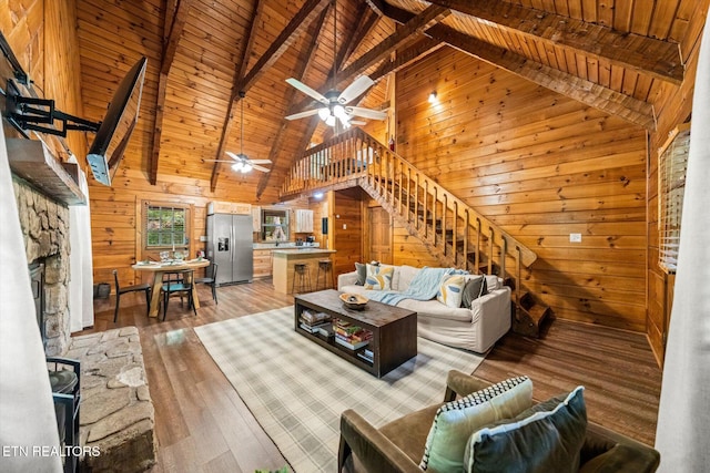 4372 Boogertown Rd Unit 4, Sevierville, TN 37876 - living room featuring wooden walls, high vaulted ceiling, stairs, ceiling fan, and light wood-type flooring
