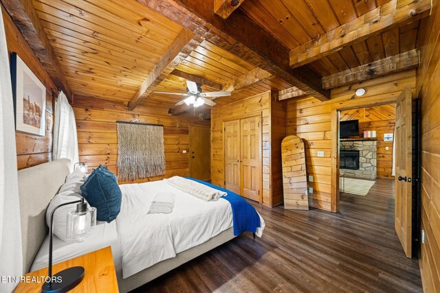 4372 Boogertown Rd Unit 4, Sevierville, TN 37876 - bedroom with a wood ceiling with exposed beams, wood walls, wood finished floors, and a stone fireplace