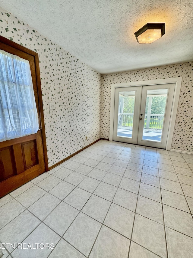 121 Ida Hertzler Ln, Knoxville, TN 37934 - unfurnished room featuring wallpapered walls, a textured ceiling, french doors, and light tile patterned floors