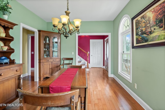 201 Locust Dr, Lafollette, TN 37766 - dining area featuring a chandelier, stairs, and light wood-type flooring