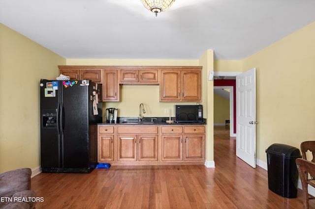 201 Locust Dr, Lafollette, TN 37766 - kitchen with black appliances, dark countertops, wood finished floors, and brown cabinetry