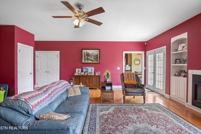 201 Locust Dr, Lafollette, TN 37766 - living area featuring wood finished floors, a ceiling fan, built in features, and a fireplace