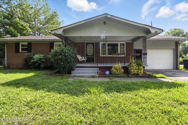 428 Wilderness Rd, Middlesboro, KY 40965 - single story home featuring a garage, brick siding, covered porch, a front lawn, and asphalt driveway