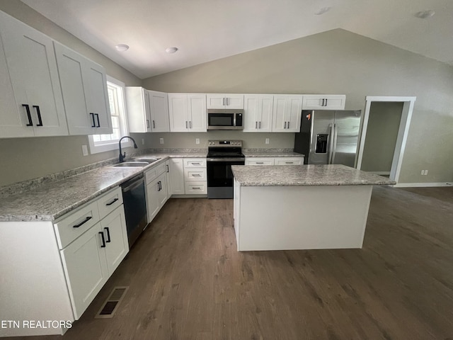1112 Whispering Pine Ln, Jamestown, TN 38556 - kitchen with appliances with stainless steel finishes, vaulted ceiling, a kitchen island, white cabinetry, and dark wood-style flooring