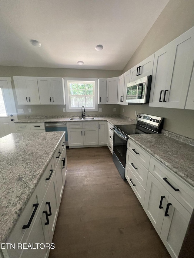 1112 Whispering Pine Ln, Jamestown, TN 38556 - kitchen featuring appliances with stainless steel finishes, white cabinetry, dark wood-style flooring, light stone countertops, and lofted ceiling