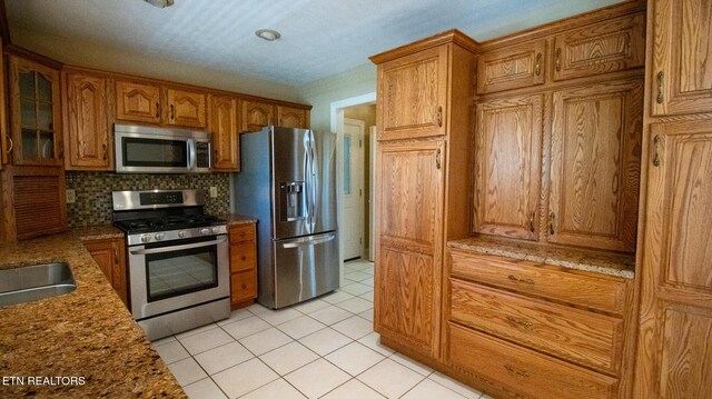 185 Florence Cir, Dandridge, TN 37725 - kitchen featuring stainless steel appliances, brown cabinets, tasteful backsplash, and light tile patterned floors