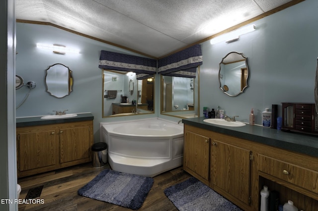 1872 Mitchell Farm Rd, Sevierville, TN 37876 - full bathroom with vaulted ceiling, wood finished floors, two vanities, a textured ceiling, and a garden tub