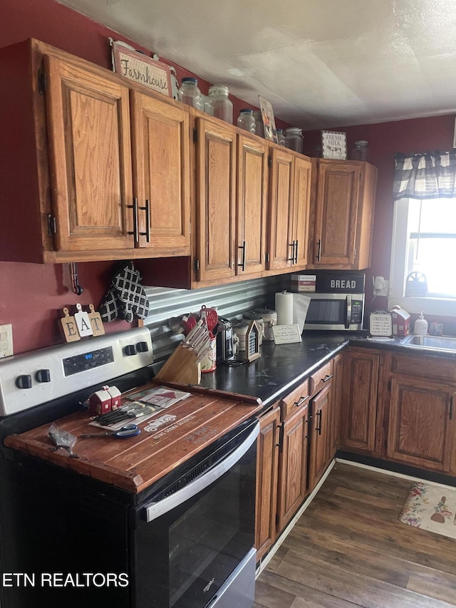 189 Bacon St, Jellico, TN 37762 - kitchen with appliances with stainless steel finishes, dark wood-type flooring, brown cabinetry, and dark countertops
