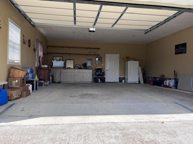 142 Lone Holly Ln, New Tazewell, TN 37825 - garage featuring freestanding refrigerator and a garage door opener
