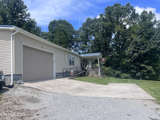 142 Lone Holly Ln, New Tazewell, TN 37825 - view of side of home with driveway, a garage, covered porch, and a yard