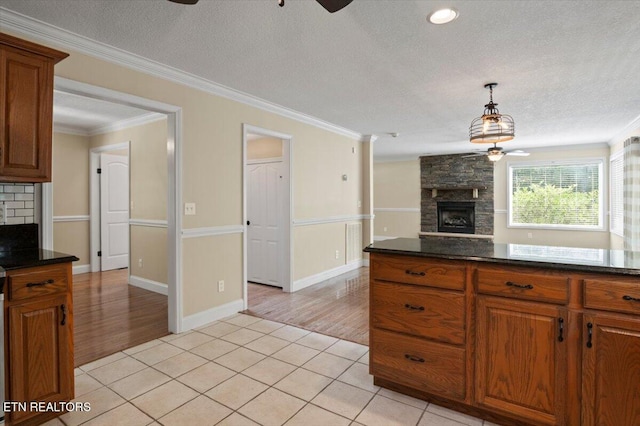 440 Indian Hills Rd, Oneida, TN 37841 - kitchen with a stone fireplace, a ceiling fan, brown cabinetry, a textured ceiling, and ornamental molding