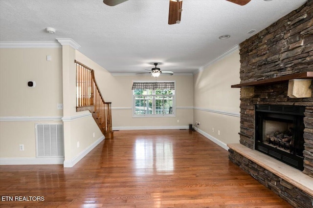 440 Indian Hills Rd, Oneida, TN 37841 - unfurnished living room featuring a ceiling fan, a stone fireplace, wood finished floors, stairway, and a textured ceiling