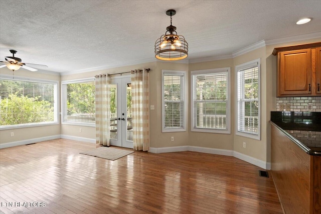 440 Indian Hills Rd, Oneida, TN 37841 - unfurnished dining area featuring a ceiling fan, a textured ceiling, wood-type flooring, plenty of natural light, and ornamental molding