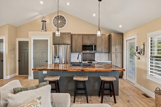 1721 Holly Bend Dr, Byrdstown, TN 38549 - kitchen with appliances with stainless steel finishes, wood counters, a center island with sink, backsplash, and light wood-style flooring