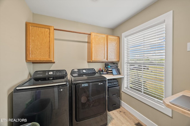 1721 Holly Bend Dr, Byrdstown, TN 38549 - laundry room with cabinet space, light wood finished floors, and washing machine and clothes dryer