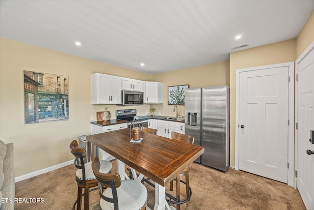 1721 Holly Bend Dr, Byrdstown, TN 38549 - kitchen with stainless steel appliances, dark countertops, light colored carpet, white cabinets, and recessed lighting