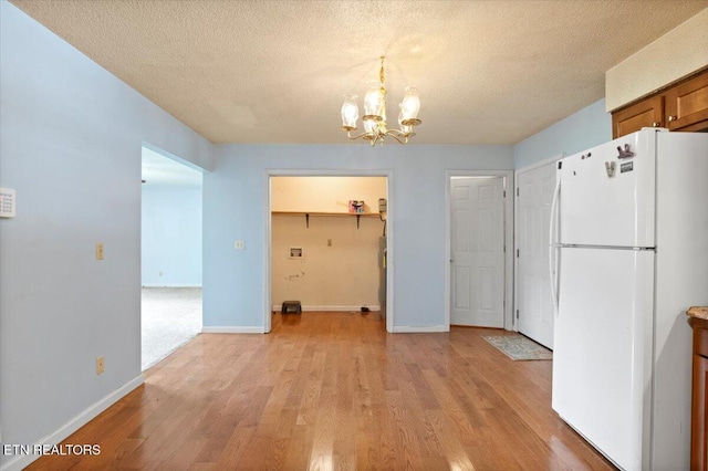 546 Park Rd, Caryville, TN 37714 - unfurnished dining area featuring a chandelier, light wood-style flooring, and a textured ceiling