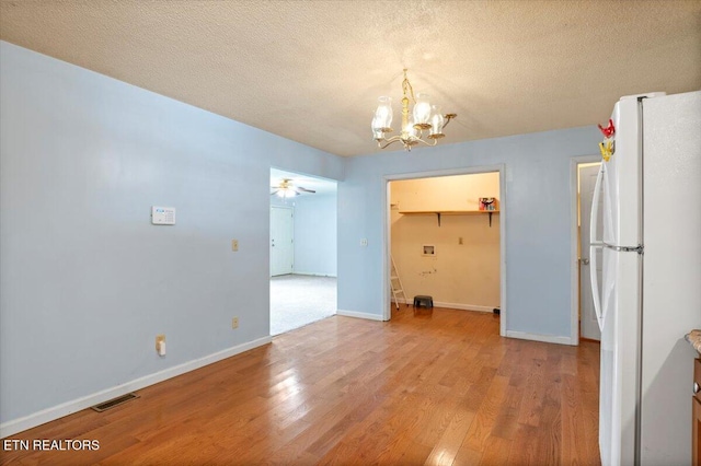 546 Park Rd, Caryville, TN 37714 - unfurnished dining area featuring a chandelier, light wood-style flooring, a textured ceiling, and a ceiling fan