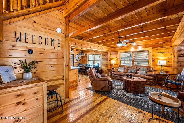3322 Covered Bridge Way, Sevierville, TN 37862 - living room with wooden walls, hardwood / wood-style floors, and a wooden ceiling with exposed beams