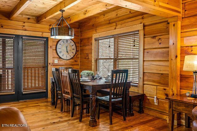 3322 Covered Bridge Way, Sevierville, TN 37862 - dining space with a wood ceiling with exposed beams, wooden walls, and hardwood / wood-style flooring