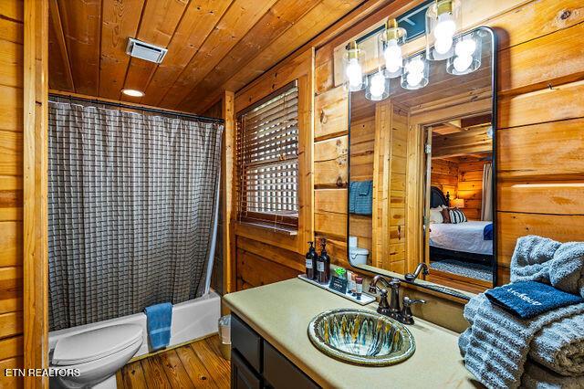 3322 Covered Bridge Way, Sevierville, TN 37862 - bathroom with wood walls, vanity, wood ceiling, wood finished floors, and shower / bathtub combination with curtain