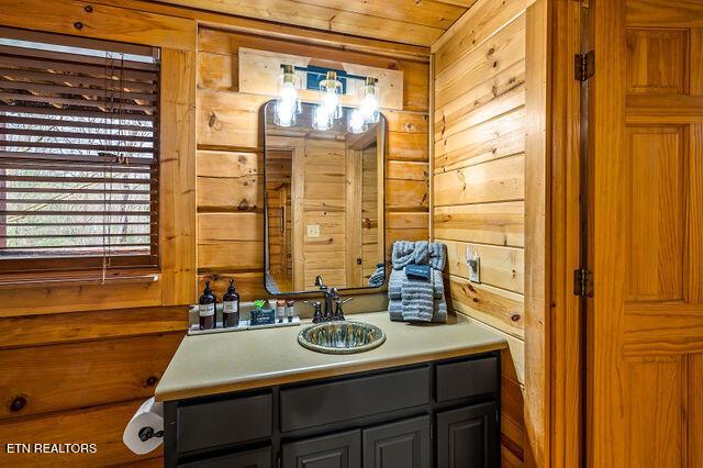3322 Covered Bridge Way, Sevierville, TN 37862 - bathroom with wood walls, vanity, wood ceiling, and a chandelier