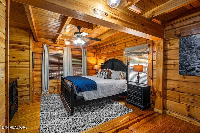 3322 Covered Bridge Way, Sevierville, TN 37862 - bedroom with a wood ceiling with exposed beams, wooden walls, and hardwood / wood-style flooring