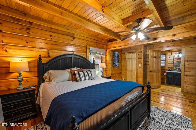 3322 Covered Bridge Way, Sevierville, TN 37862 - bedroom featuring wood walls, light wood finished floors, and a wood ceiling with exposed beams