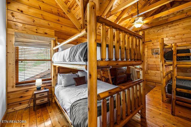 3322 Covered Bridge Way, Sevierville, TN 37862 - bedroom featuring wood-type flooring, wood walls, and lofted ceiling