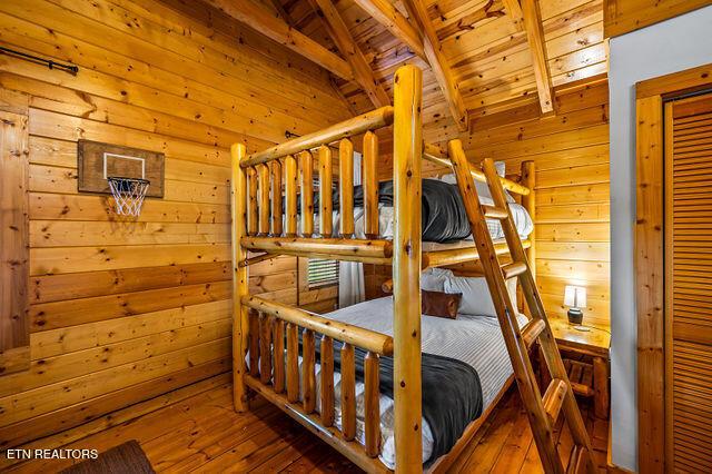 3322 Covered Bridge Way, Sevierville, TN 37862 - bedroom featuring wood ceiling, wood walls, and hardwood / wood-style flooring