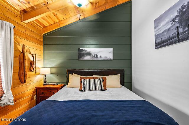 3322 Covered Bridge Way, Sevierville, TN 37862 - bedroom featuring wood walls and a wooden ceiling with exposed beams