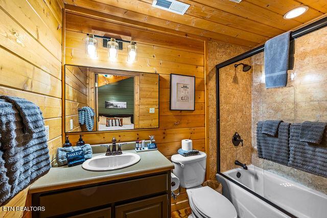 3322 Covered Bridge Way, Sevierville, TN 37862 - bathroom featuring vanity, wood walls, bath / shower combo with glass door, and wood ceiling