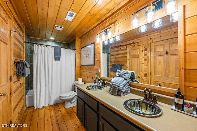 3322 Covered Bridge Way, Sevierville, TN 37862 - bathroom featuring double vanity, wood walls, hardwood / wood-style floors, shower / bath combination with curtain, and wood ceiling