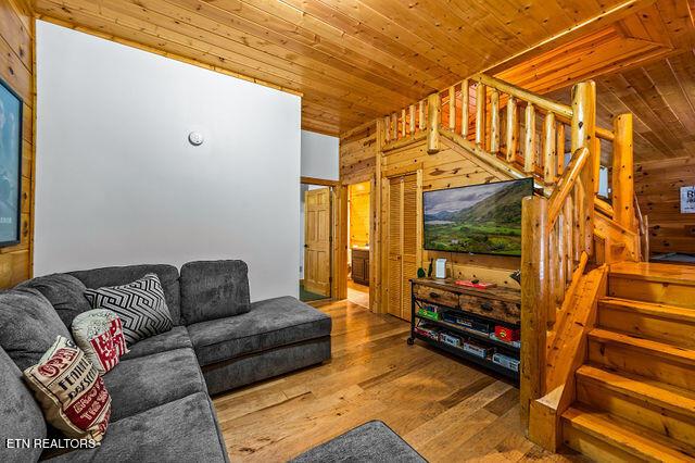 3322 Covered Bridge Way, Sevierville, TN 37862 - living room with stairway, wood walls, wood ceiling, and wood finished floors