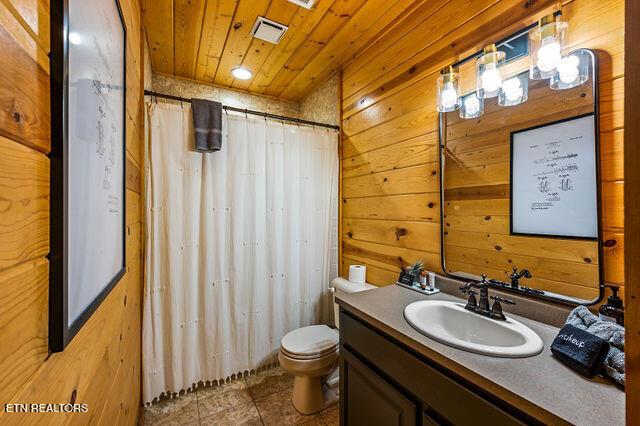 3322 Covered Bridge Way, Sevierville, TN 37862 - bathroom with vanity, wooden ceiling, wooden walls, tile patterned floors, and curtained shower